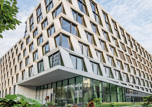 Architecture moderne de l’immeuble de bureaux du projet ONE PLAZA avec une façade distinctive et de grandes surfaces vitrées.